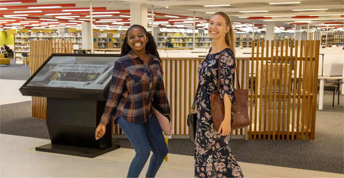 Two students posing at kiosk in SU Library