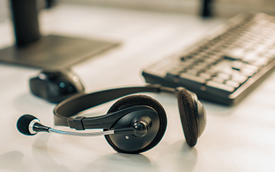 Earphones and microphone with a compute keyboard in the background