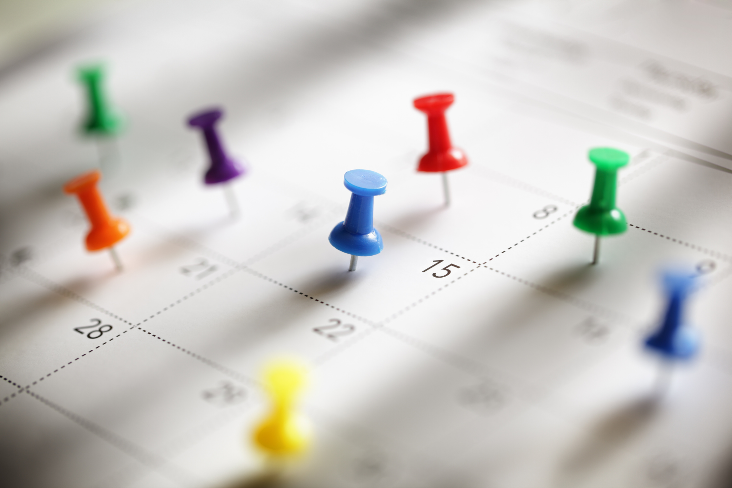 close up image of a calendar with pins in certain dates