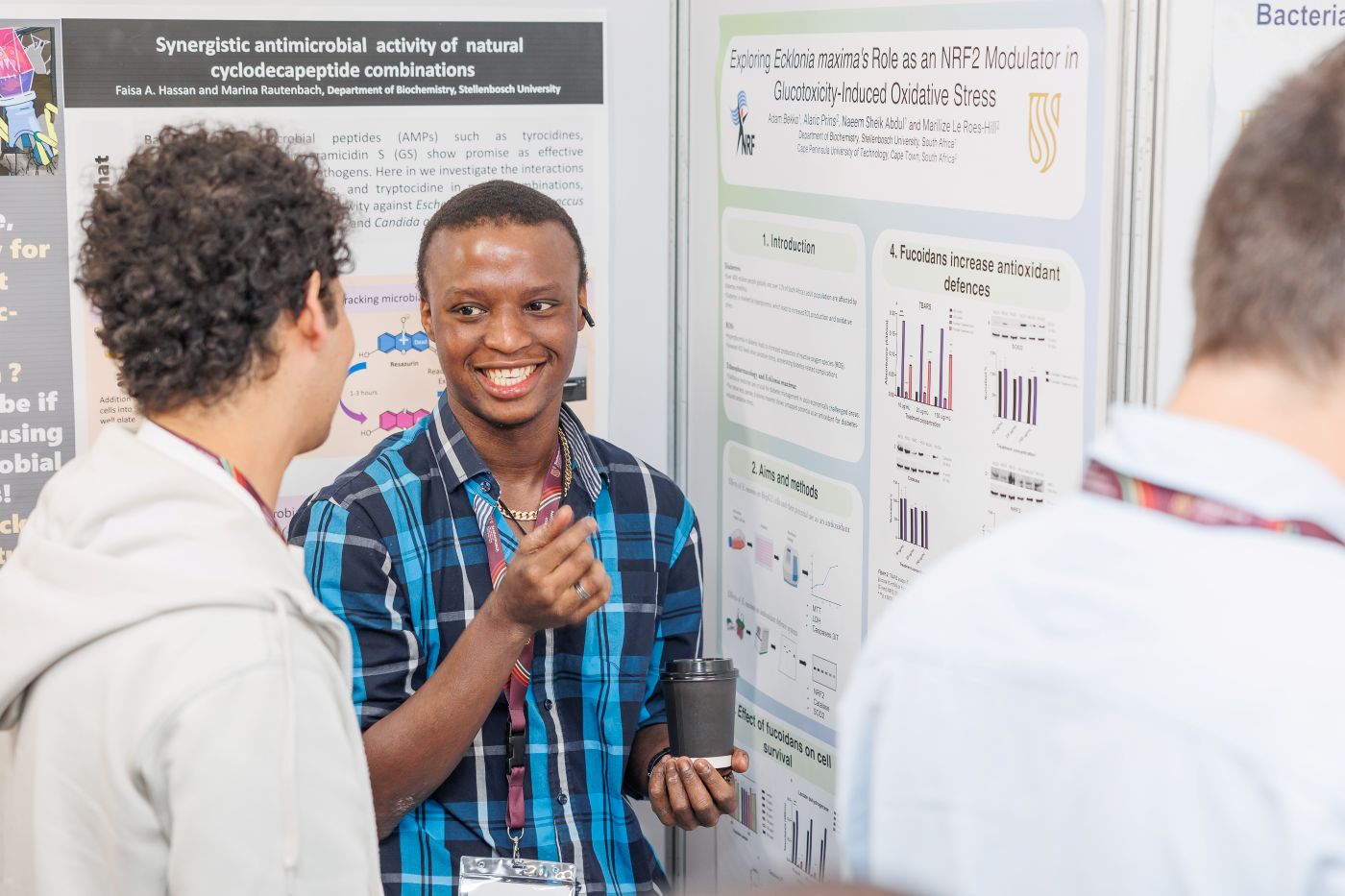 Postgraduate BSc student explains his research to a fellow student.