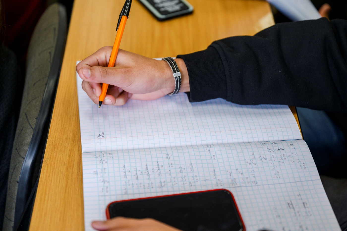 First year science student taking notes during a maths lecture.