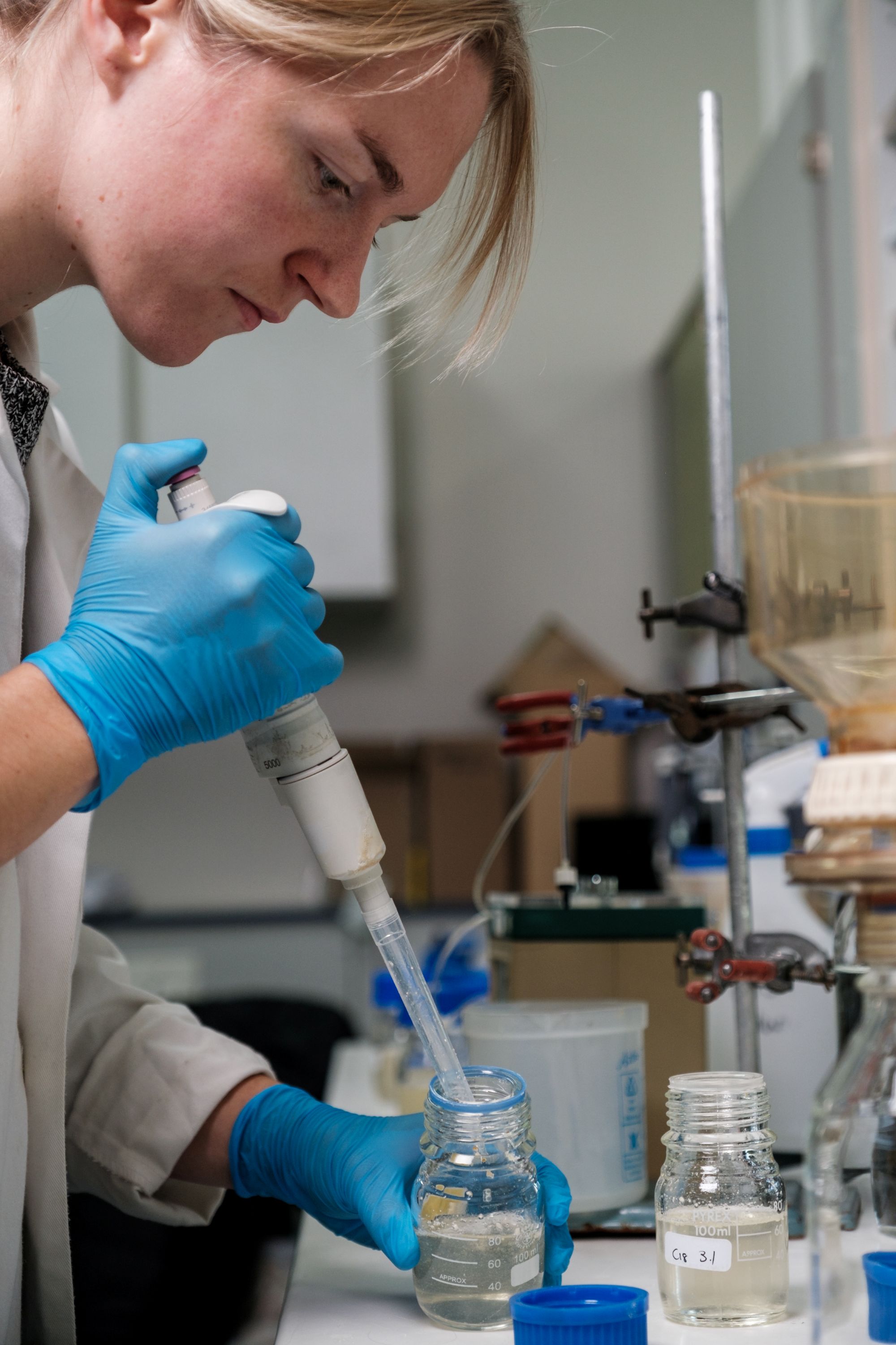 In the Department of Microbiology, a postgraduate student is making an extraction for analysis.