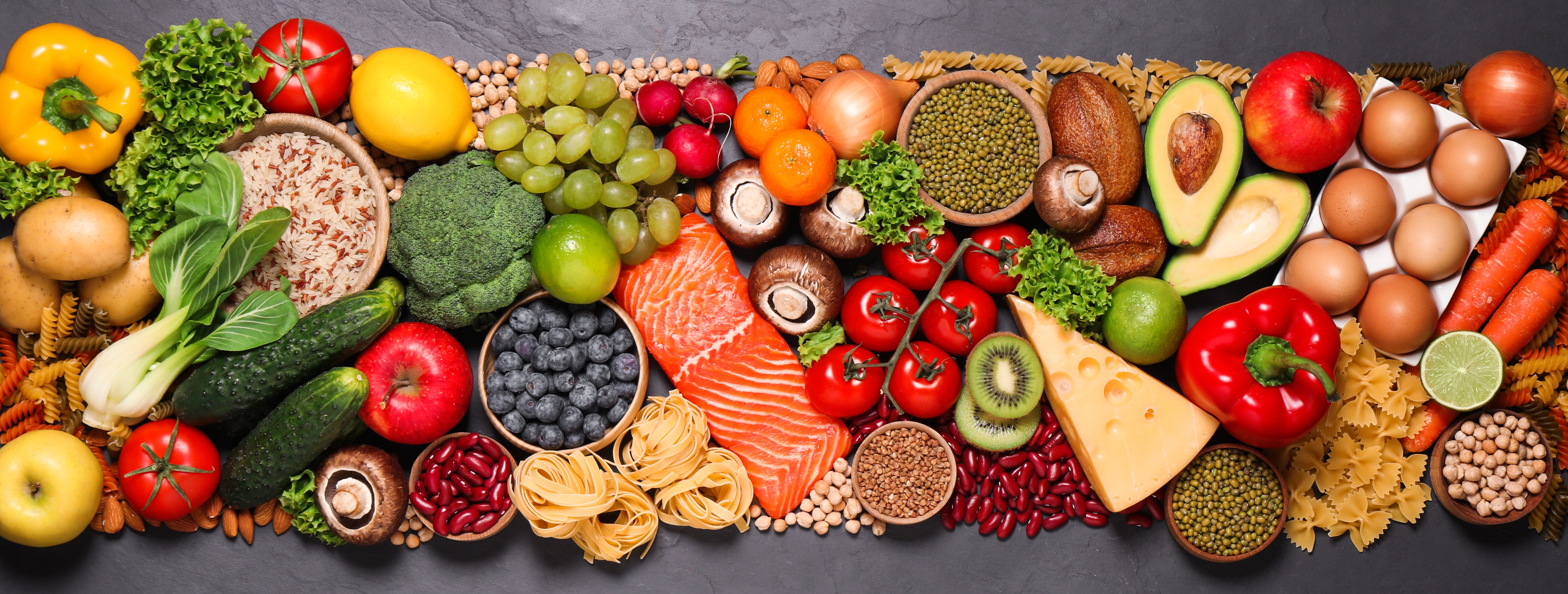 Different healthy food products photographed on a black table