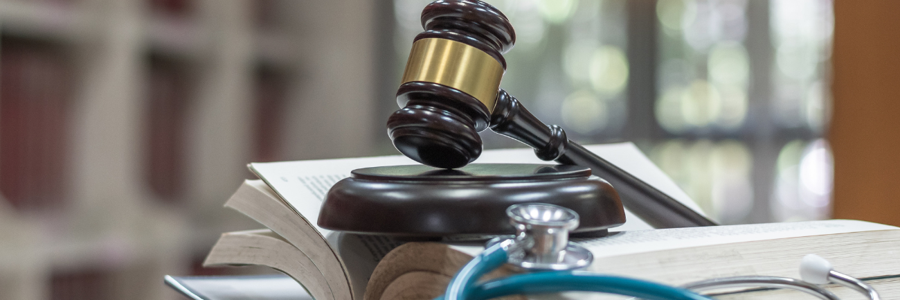 A picture of judge’s gavel on a law textbook for criminal and civil laws in a library.