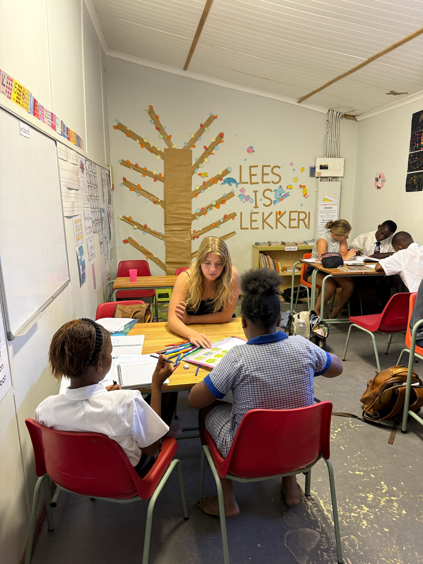 Photo of two students sitting at separate tables involved in experiential learning opportunity while engaging with school learners