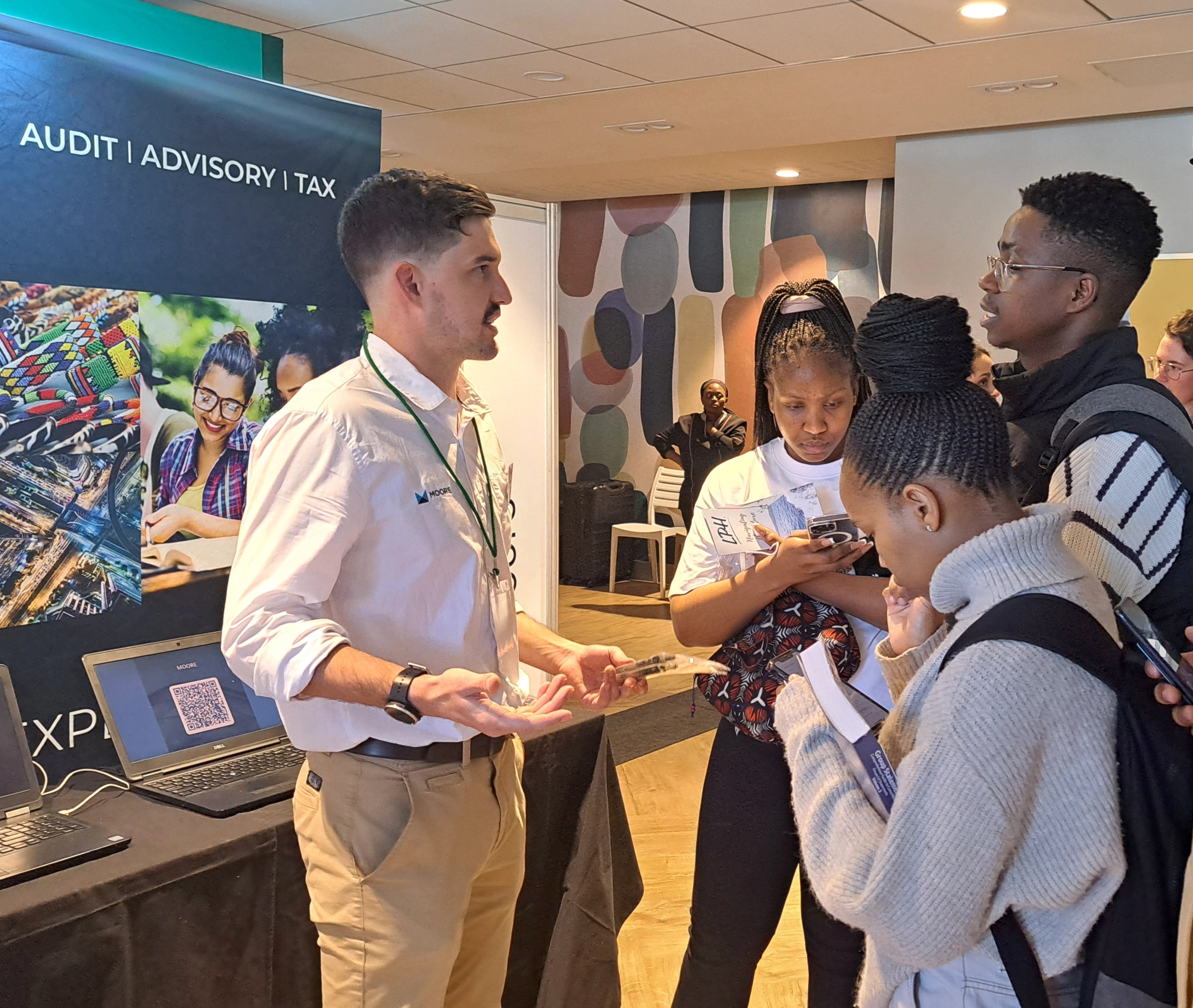 A photo of students speaking to a company representative at the Unit for Graduand Career Services Careers Fair