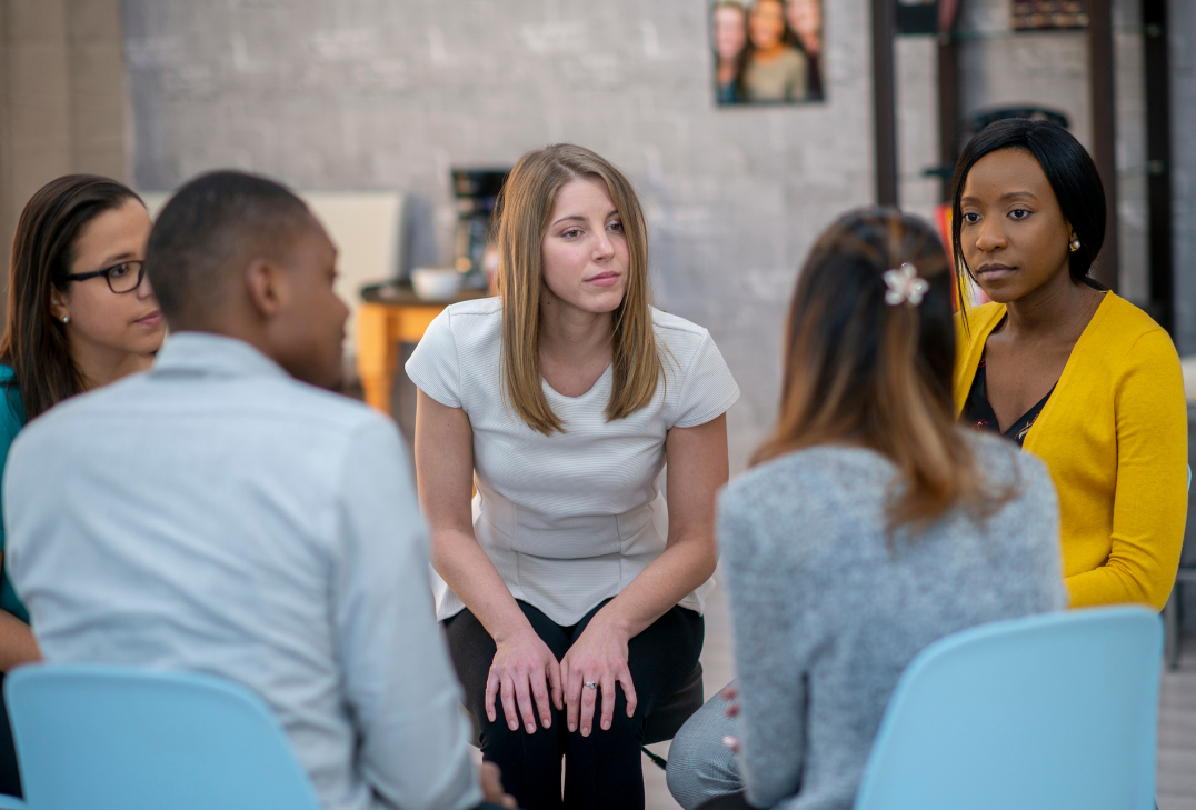 Photo of diverse students in group therapy session