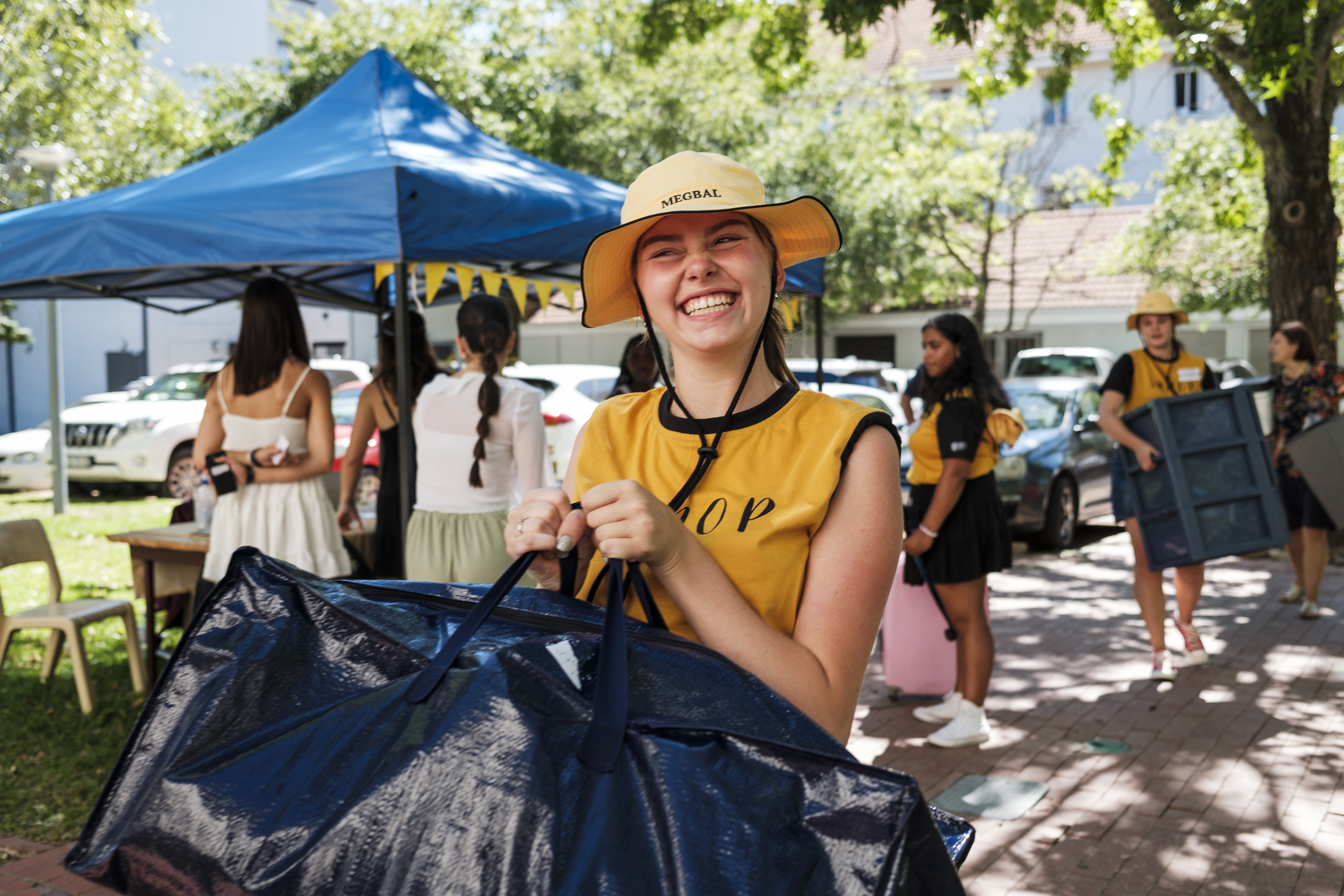Photo of Sonop residence leader carrying a bag into residence.
