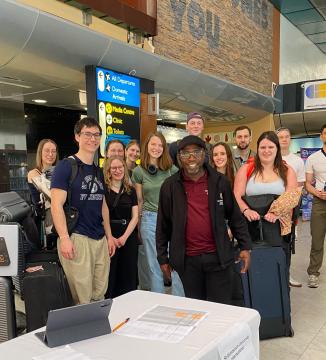 International Student and SUI Driver, Moses Shambare, standing with a cohort of short-term international students at the Airport Arrivals in Cape Town