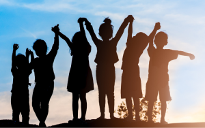 A silhouette of children playing in the sunset.