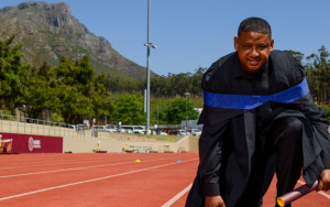 Dyan Buis photographed with his Master’s degree at the Coetzenburg Athletics Stadium in Stellenbosch.