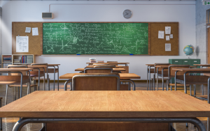 A traditional high school classroom with individual desks and chairs.