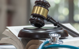 A picture of judge’s gavel on a law textbook for criminal and civil laws in a library.