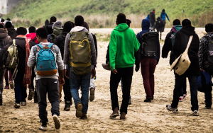 A group of African migrants on the move with the backs to the camera.