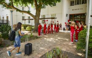 A photo of a student moving into Minerva Residence and being welcomed by student leaders from the residence dressed in red.