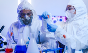 Team of scientists in hazmat suits and respirators conducting a critical experiment