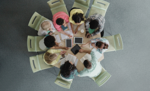 Group of people sitting around a table. Image taken from the top