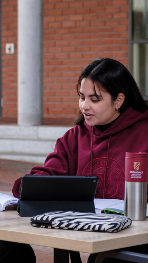 Student sitting at table in front of a tablet