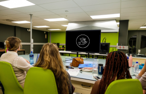 Click the icon to access funding opportunities. Picture of students in front of computer screen.