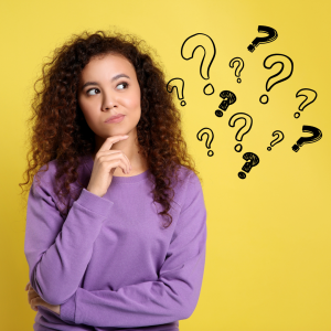 Stock photo of student with curly hair and purple top thinking with question marks appearing next to her head.