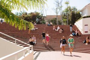 student riding a bike in front of the krotoa building
