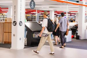 su student carry a skateboard in the library 