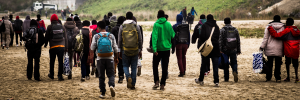 A group of African migrants on the move with the backs to the camera.